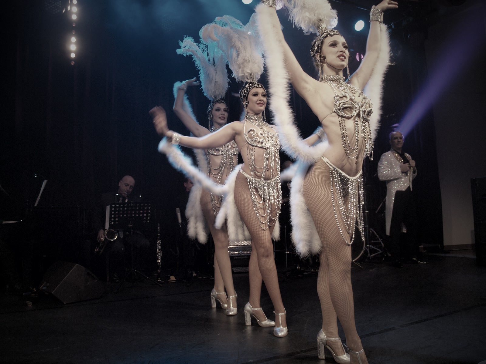 Showgirls com plumas brancas em palco